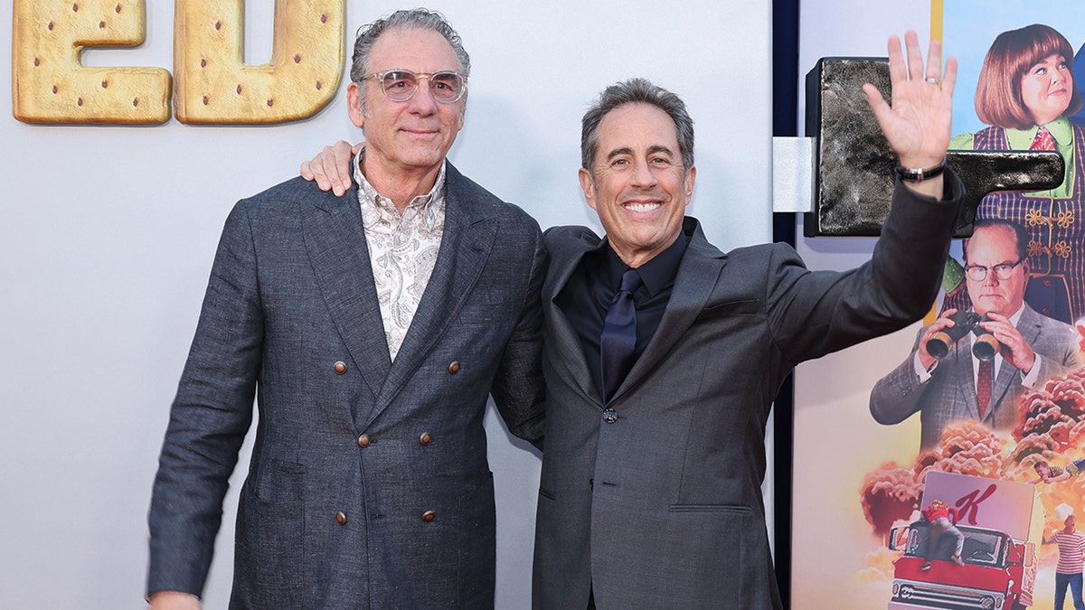 Michael Richard and Jerry Seinfeld on the carpet with Jerry's arm extended