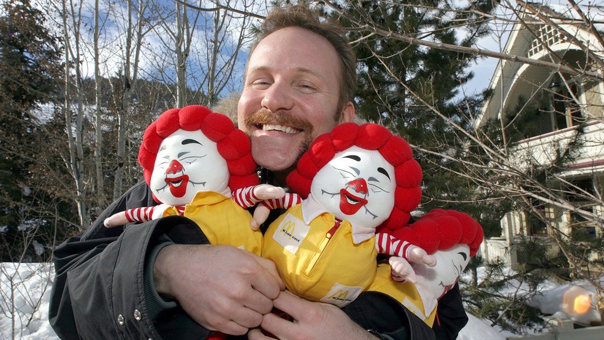 Morgan Spurlock holds small McDonald's characters