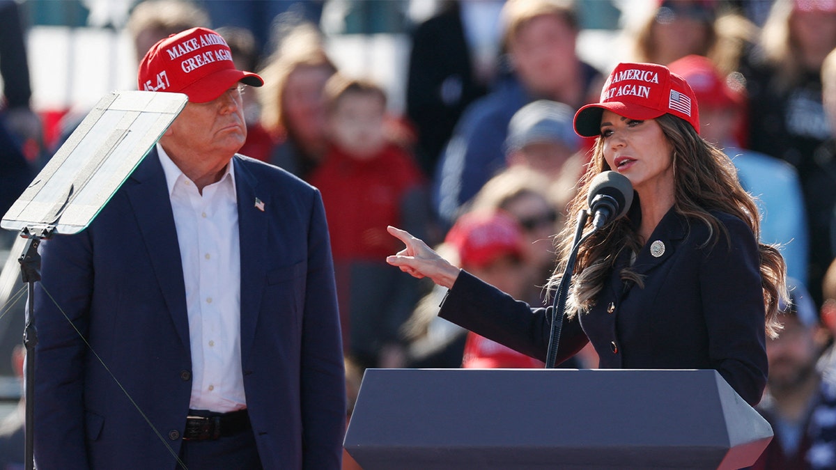 (L-R) Former US President and Republican presidential candidate Donald Trump listens as North Dakota Governor Kristi Noem speaks during a Buckeye Values PAC Rally in Vandalia, Ohio, on March 16, 2024.