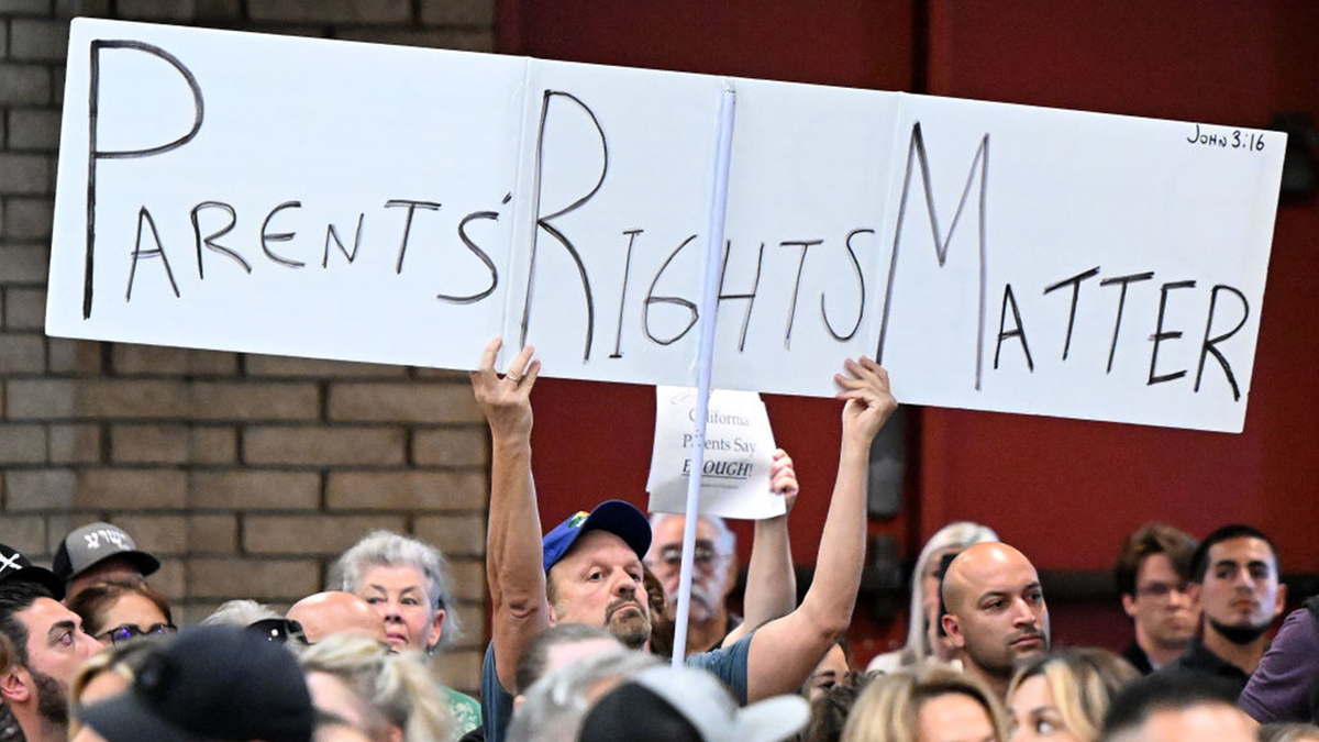 A parents rights supporter holds up a sign.