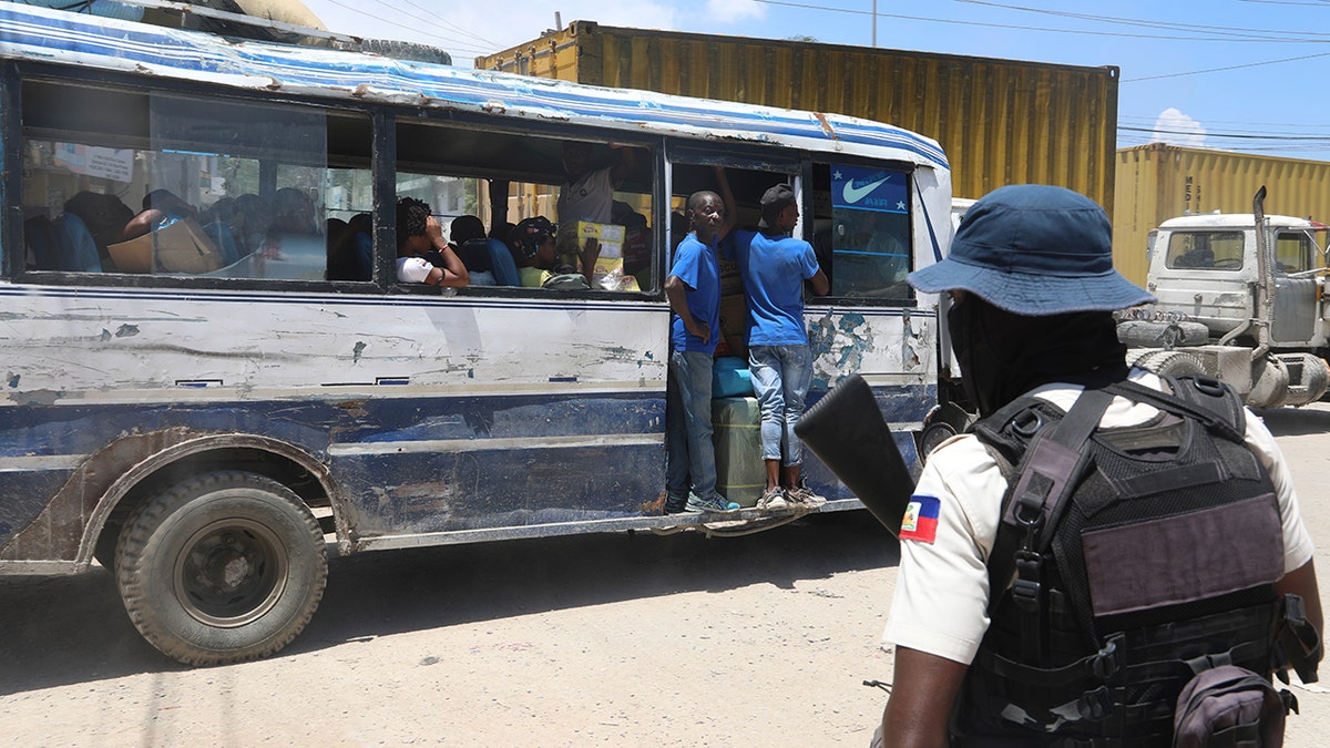 A bus passes by a police officer in Port-au-Prince, Haiti