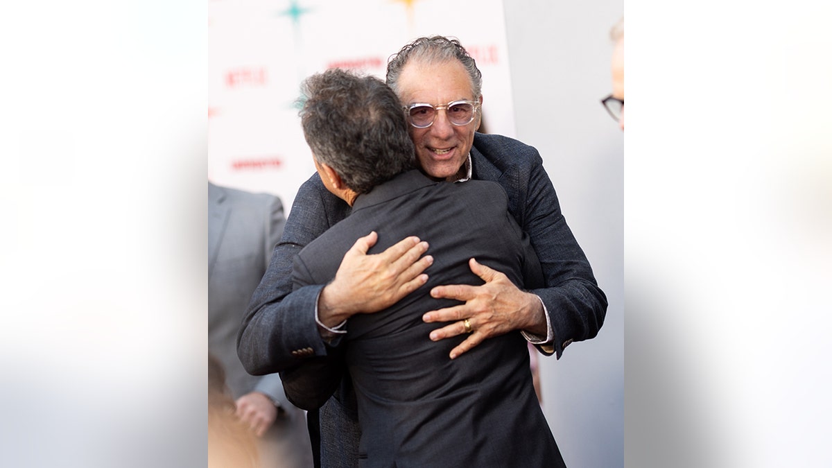 Michael Richards hugs Jerry Seinfeld connected nan carpet