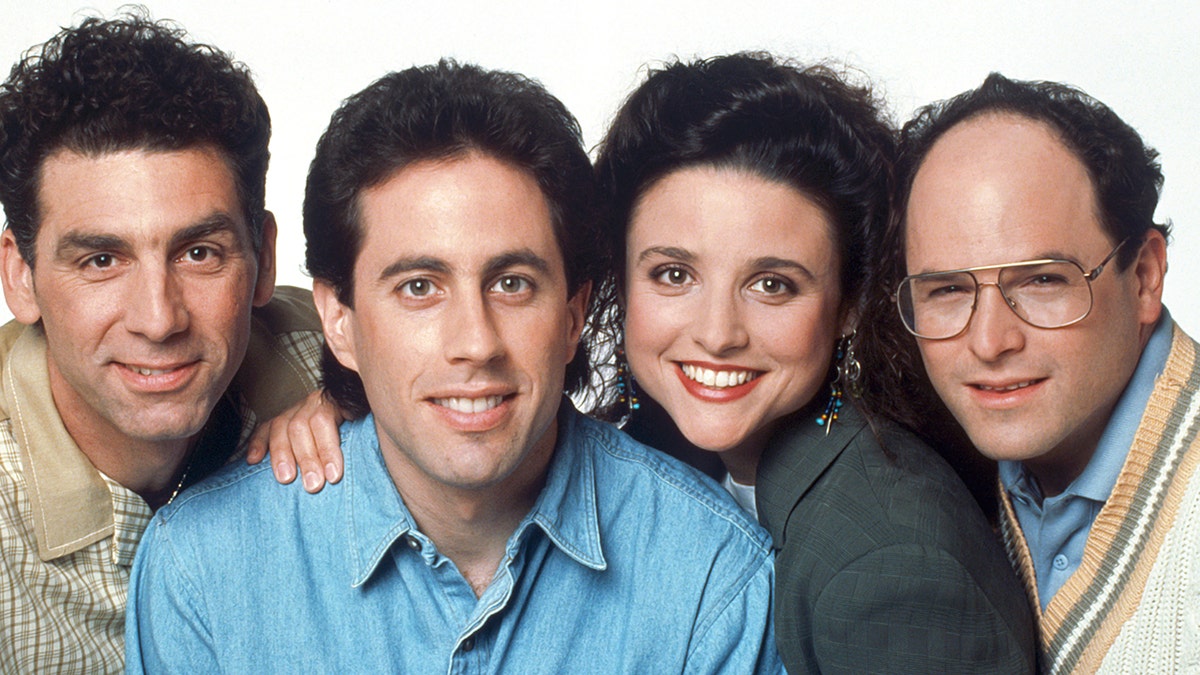 Michael Richards as Cosmo Kramer, Jerry Seinfeld as Jerry Seinfeld, Julia Louis-Dreyfus as Elaine Benes, Jason Alexander as George Costanza in a picture from the show "Seinfeld" all squeezing together