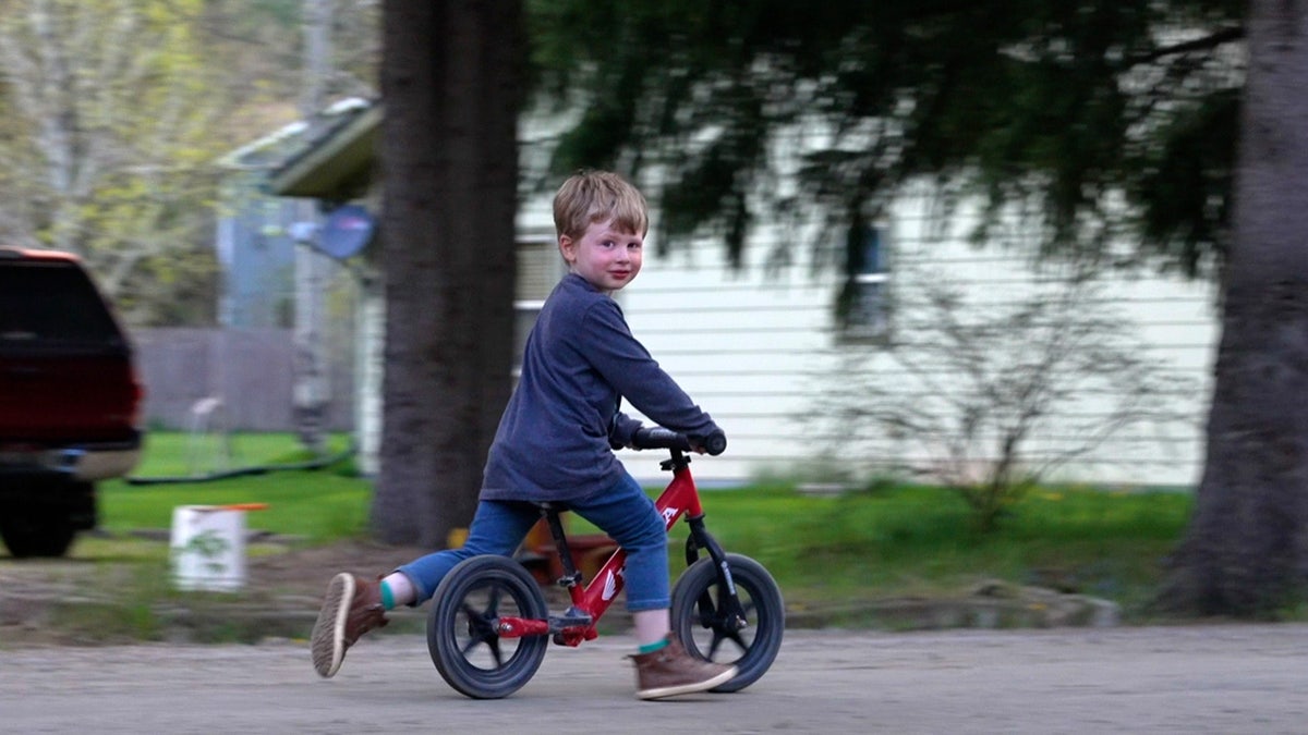 Boy rides push-bike on gravel road