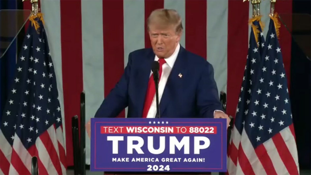 Donald Trump with US flags behind him