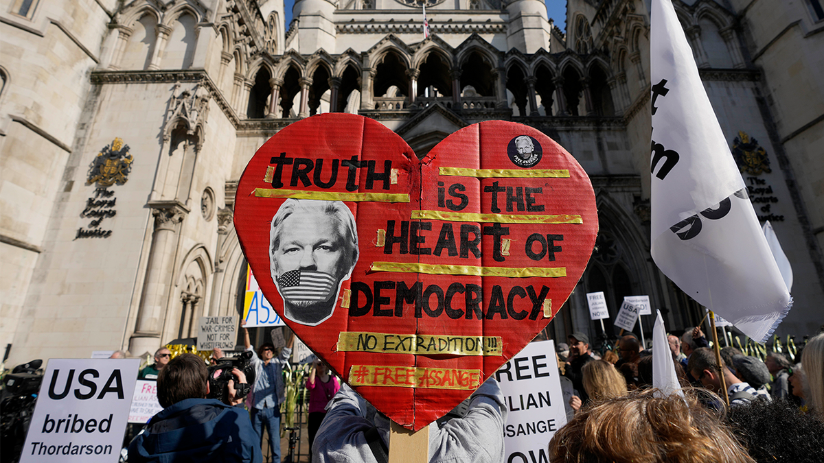 Protesters hold placards outside the High Court in London.