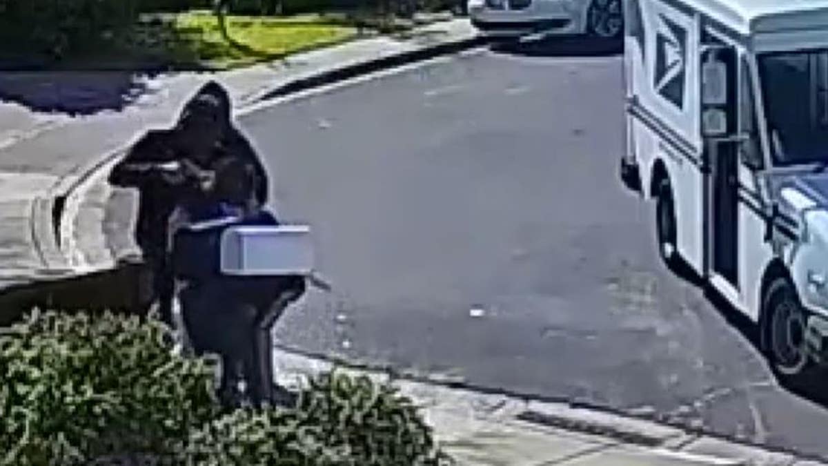 The postal worker being robbed at gunpoint