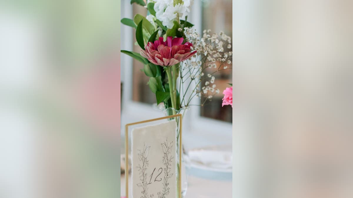 Meja pernikahan dengan hiasan bunga di tengahnya
