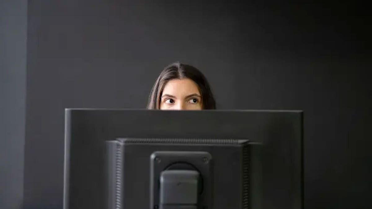 Worker peaks behind computer