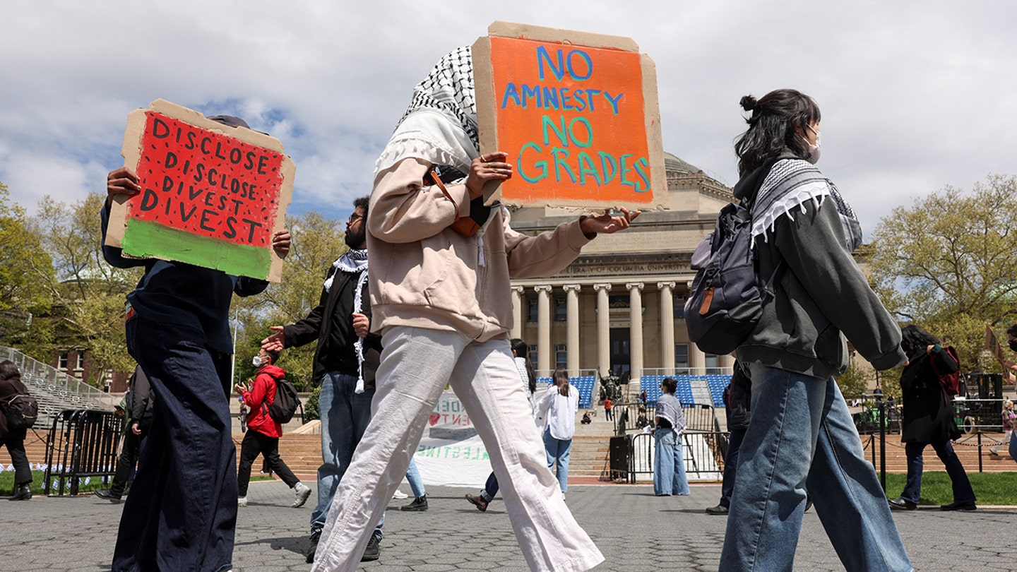 Columbia University student in handcuffs rips up diploma on commencement stage in act of protest