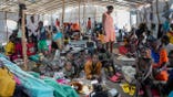 Sudanese refugees in a crowded building.
