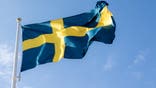 Swedish flag flying with a blue-sky background