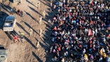 EAGLE PASS, TEXAS - DECEMBER 18: As seen from an aerial view Texas National Guard troops watch over more than 1,000 immigrants who had crossed the Rio Grande overnight from Mexico on December 18, 2023 in Eagle Pass, Texas. A surge as many as 12,000 immigrants per day crossing the U.S. southern border has overwhelmed U.S. immigration authorities in recent weeks. (Photo by John Moore/Getty Images)