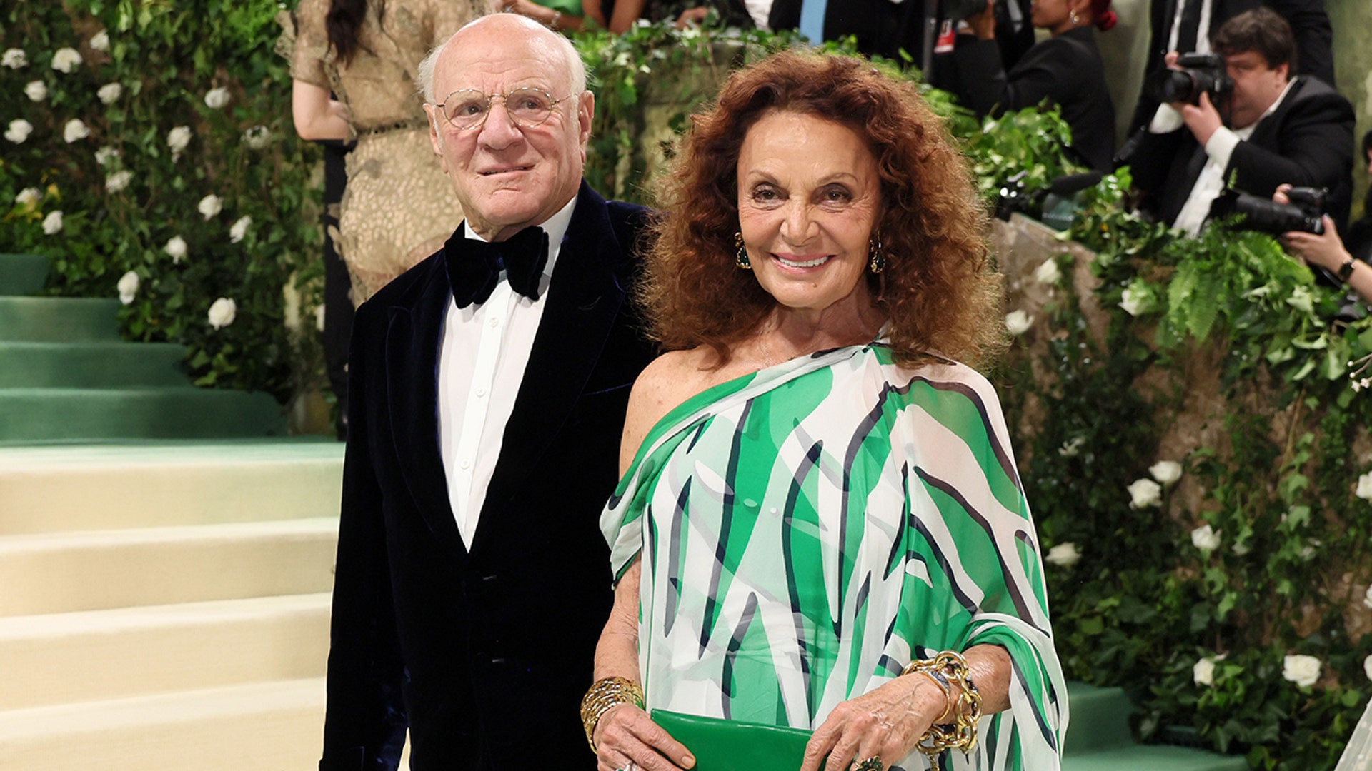 Diane Von Furstenberg at the Met Gala 2024 red carpet in a green and white print dress.