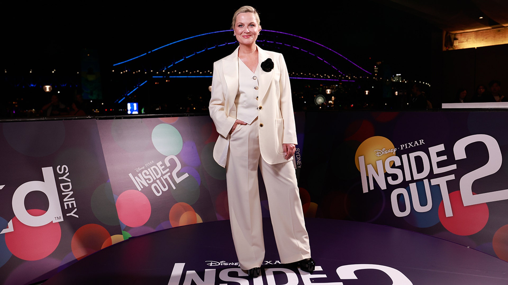 Amy Poehler attended the "In Conversation with Amy Poehler" event in Australia wearing a tailored three piece cream suit, accessorizing with a black floral lapel.
