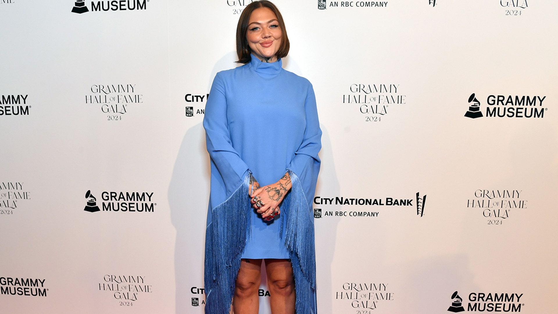 Elle King at the GRAMMY Hall Of Fame Gala in a long-sleeved blue minidress with fringe on the sleeves.