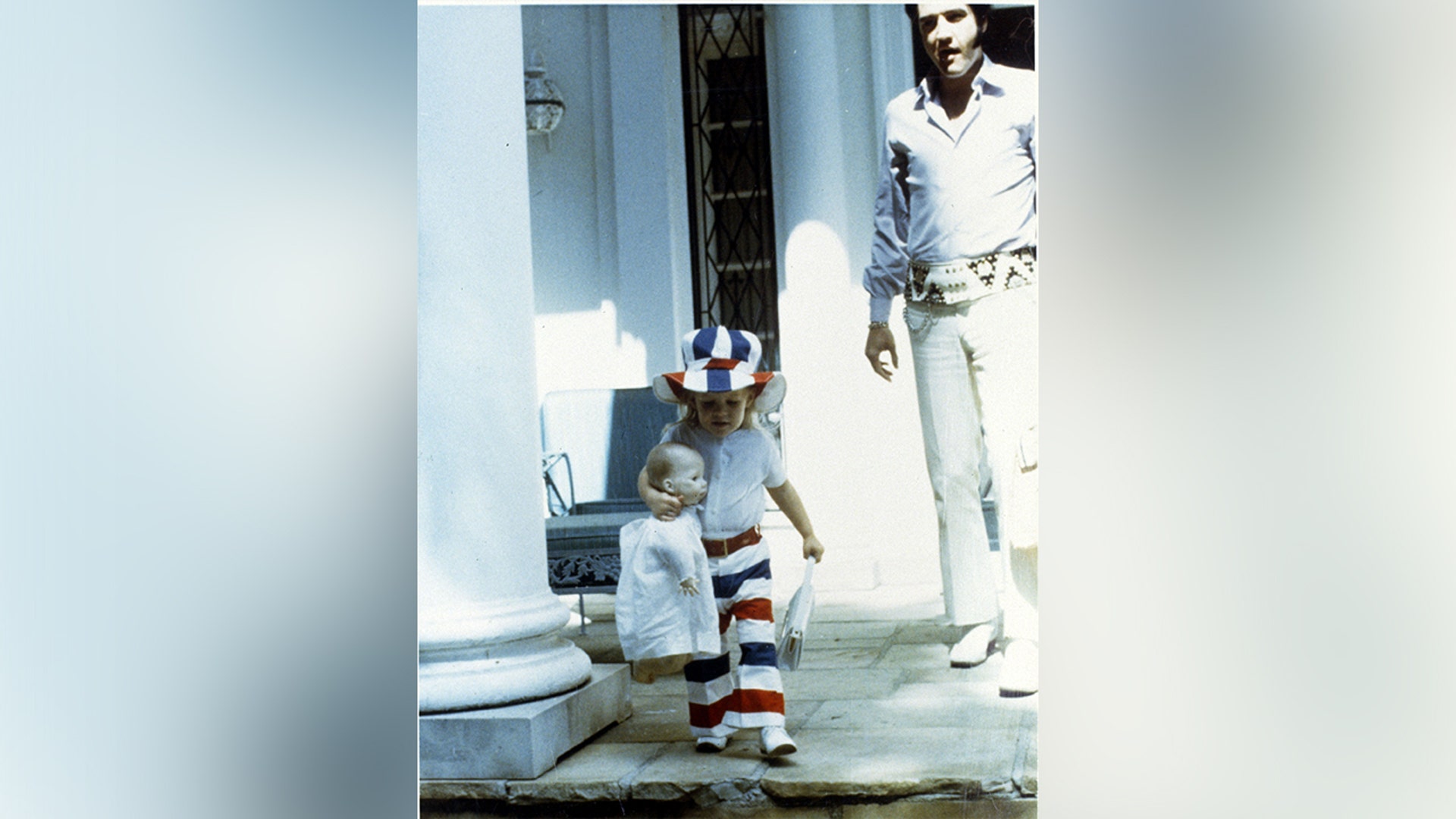 Elvis Presley and Lisa Marie near the front door of Graceland