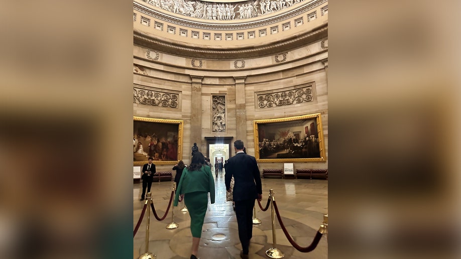 A man and woman walk in the U.S. Capitol