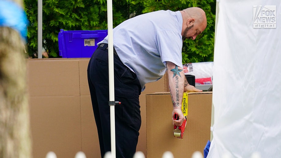 New York State and Suffolk County investigators remove bags of items marked with evidence tape from Rex Heuermann’s home in Massapequa Park