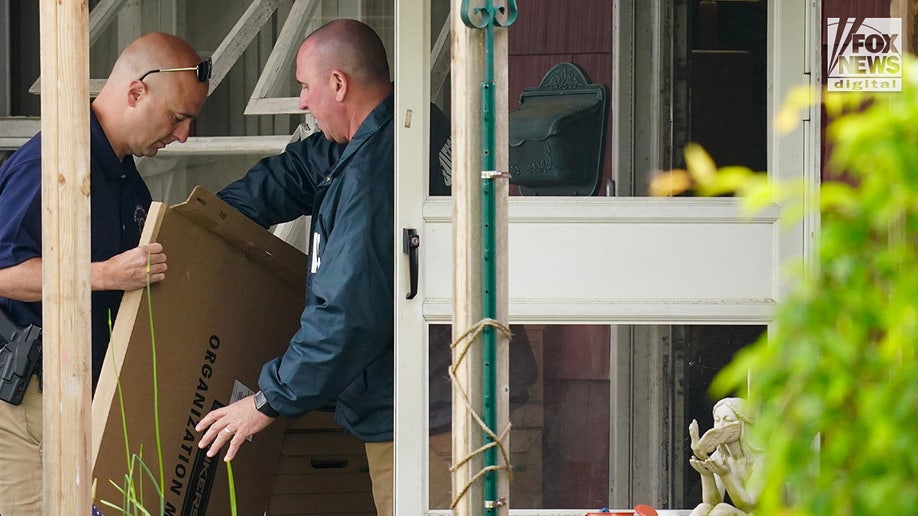 New York State and Suffolk County investigators remove bags of items marked with evidence tape from Rex Heuermann’s home in Massapequa Park