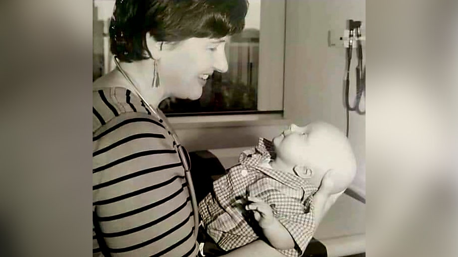 A doctor smiling at a baby