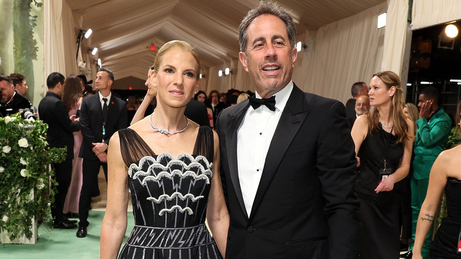 Jerry Seinfeld and his wife Jessica Seinfeld at the Met Gala 2024 red carpet in a black suit and black and white dress.