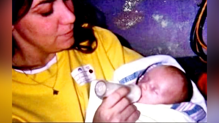 A woman feeding a small baby a bottle