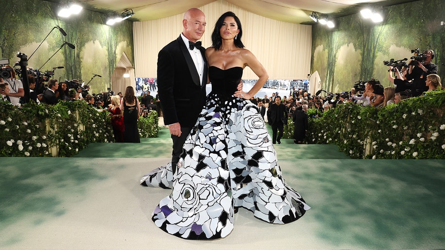 Jeff Bezos and Lauren Sanchez smiled at the top of the stairs for the Met Gala 2024.