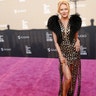 Jewel at the LGBT Center Gala in a sequined gold dress with feathers, a plunging neckline and a fringe skirt.