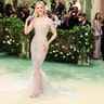 Elle Fanning at the Met Gala 2024 red carpet in a semi sheer Balmain dress and Cartier jewelry.