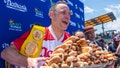 FILE - Joey Chestnut, winner of the 2021 Nathans Famous Fourth of July International Hot Dog-Eating Contest, poses for photos in Coney Islands Maimonides Park, July 4, 2021, in the Brooklyn borough of New York.