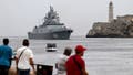 People look at the class frigate Admiral Gorshkov, part of the Russian naval detachment visiting Cuba, arriving at Havana's harbour, June 12, 2024. The Russian nuclear-powered submarine Kazan -- which will not be carrying nuclear weapons -- and three other Russian naval vessels, will dock in the Cuban capital from June 12-17. The unusual deployment of the Russian military so close to the United States -- particularly the powerful submarine -- comes amid major tensions over the war in Ukraine, where the Western-backed government is fighting a Russian invasion. (Photo by Yamil LAGE / AFP) (Photo by YAMIL LAGE/AFP via Getty Images)