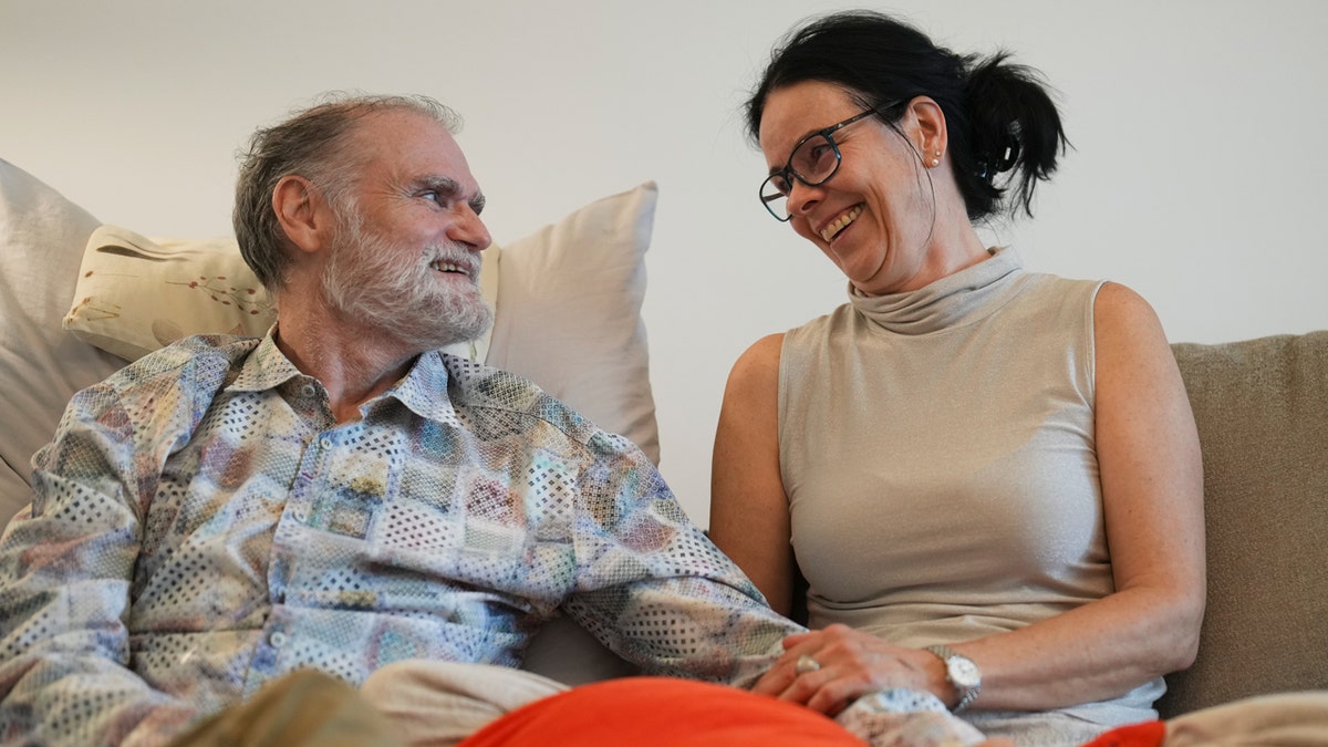 Michael Bommer, left, who is terminally ill with colon cancer, looks at his wife Anett Bommer, right, at his home in Berlin, Germany.