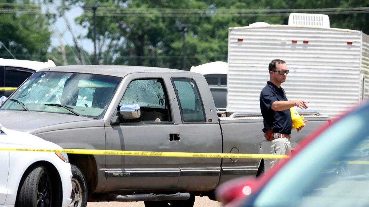 Law enforcement officers work the scene of a shooting at the Mad Butcher grocery store in Fordyce, Arkansas, on Friday.