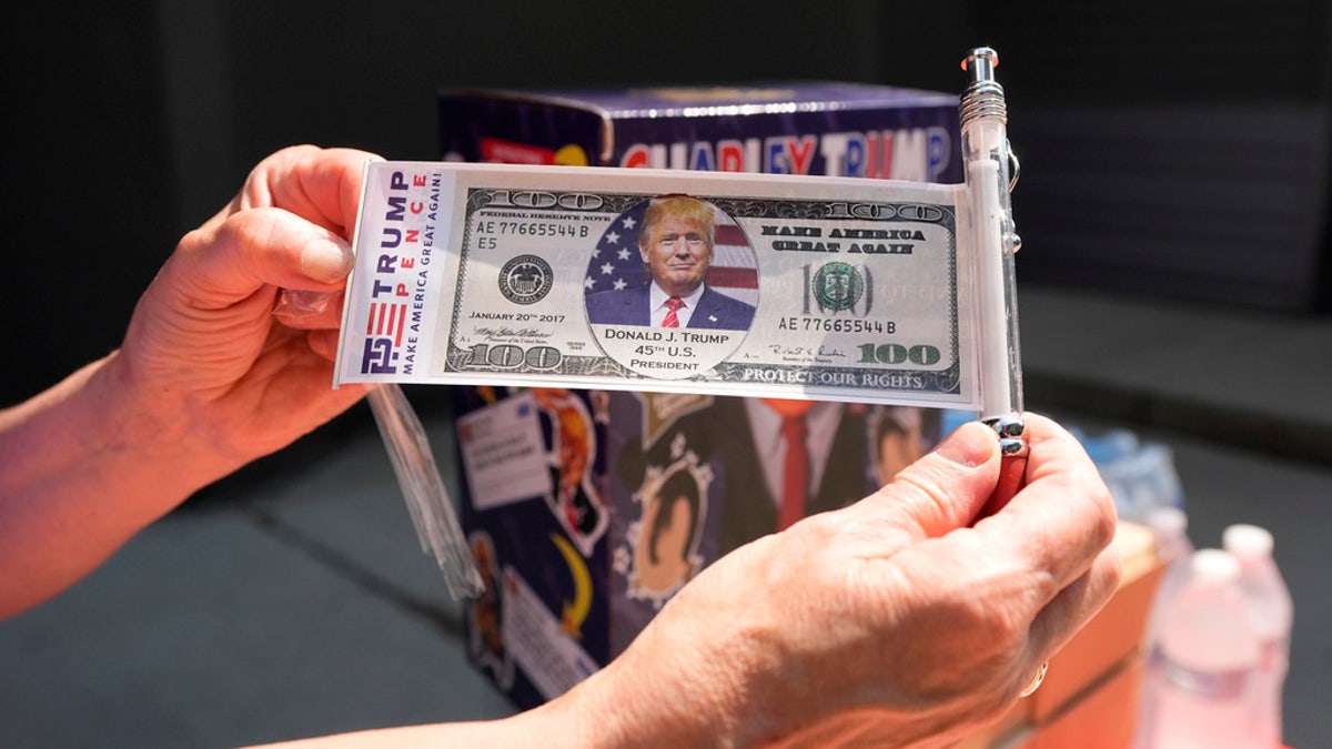 Fan holds a Trump dollar ahead of rally