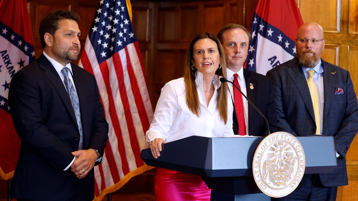 Arkansas Gov. Sarah Huckabee Sanders stands at a podium surrounded by colleagues as she speaks about tax cut bills in the Arkansas state Capitol in Little Rock.