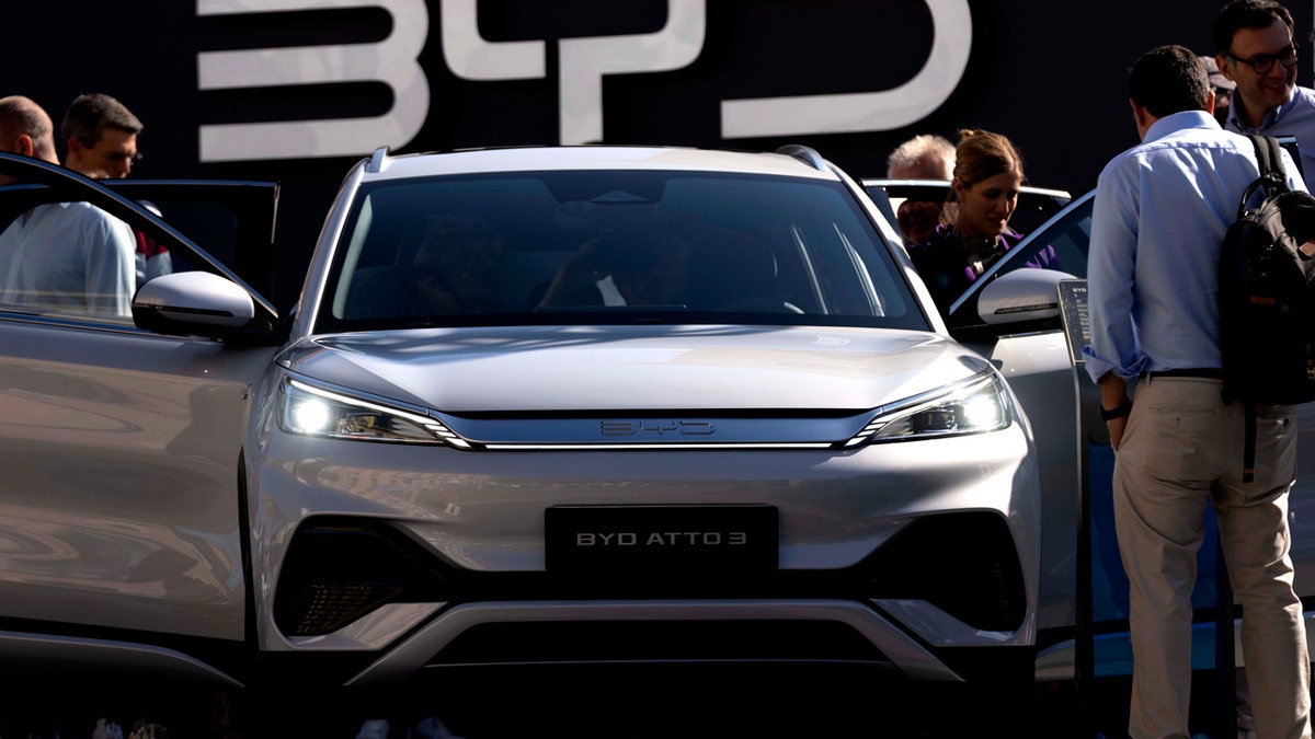 Visitors inspect the sleek, silver China-made BYD ATTO 3 at the IAA motor show in Munich.