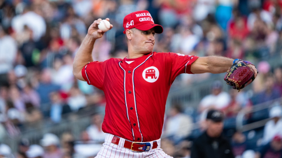Rep. Greg Steube, R-Fla., wears a red GOP team uniform and a MAGA hat as he pitches during the 2023 Congressional Baseball Game at National Park in Washington.