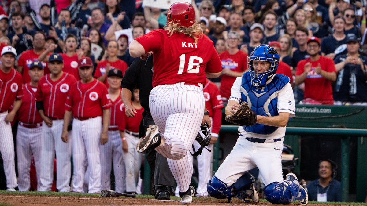 Rep. Kat Cammack, R-Fla., runs home as Sen. Chris Murphy, D-Conn., braces for a collision at the plate during the first inning of the Congressional Baseball Game at Nationals Park in Washington.