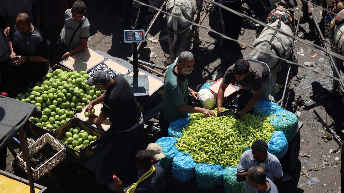 People buy food at a market in Deir al-Balah, central Gaza Strip, on June 21, 2024.