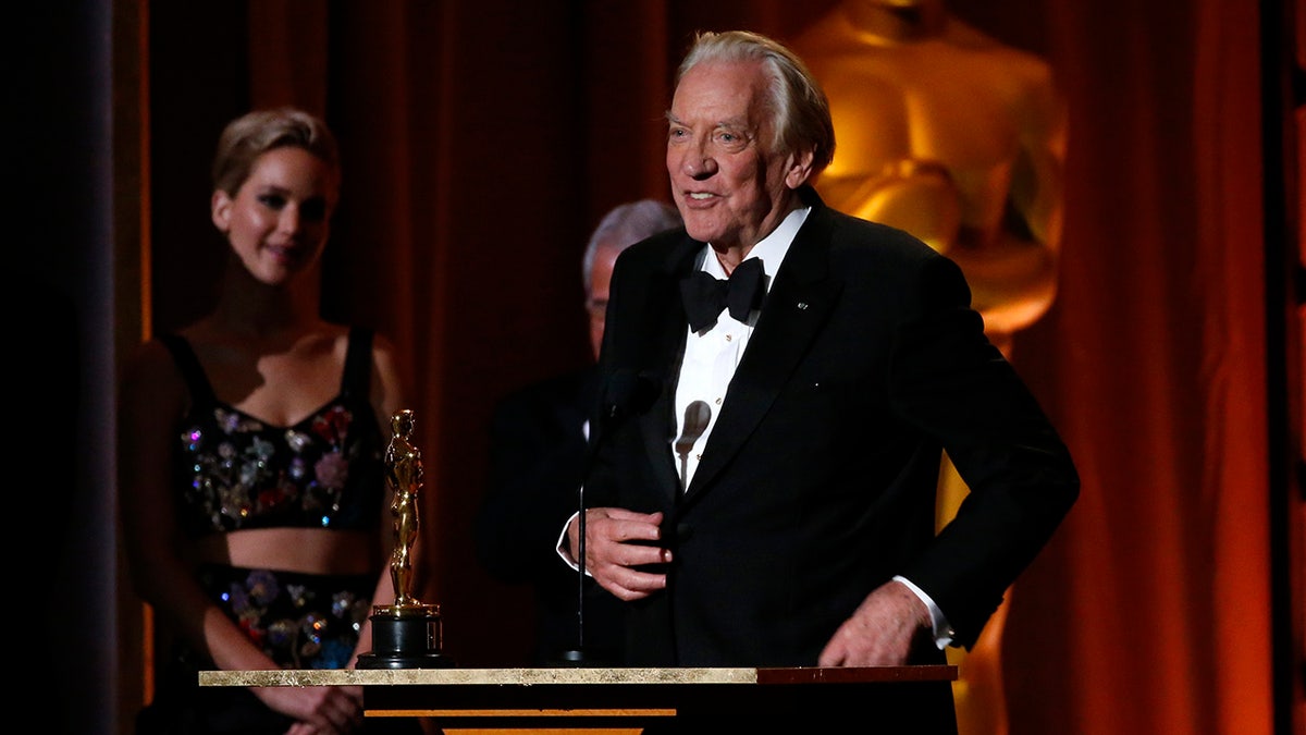 Donald Sutherland wears a suit while accepting an award
