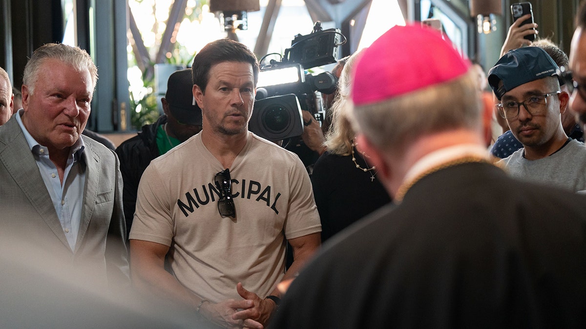 Mark Wahlberg looking at a bishop at his restaurant