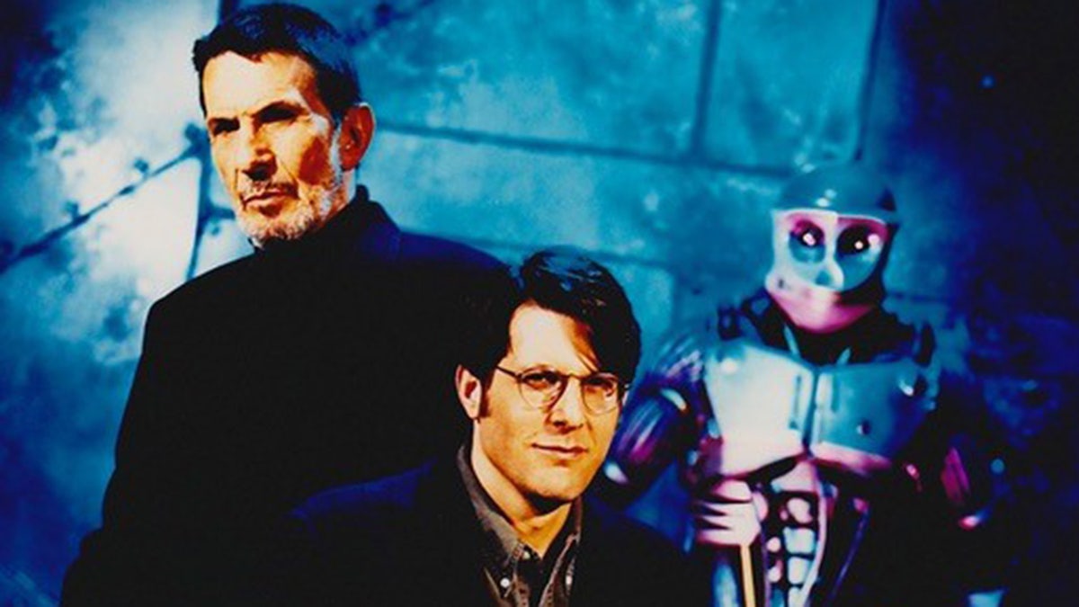 Leonard Nimoy and Adam Nimoy posing in matching suits in front of a robot