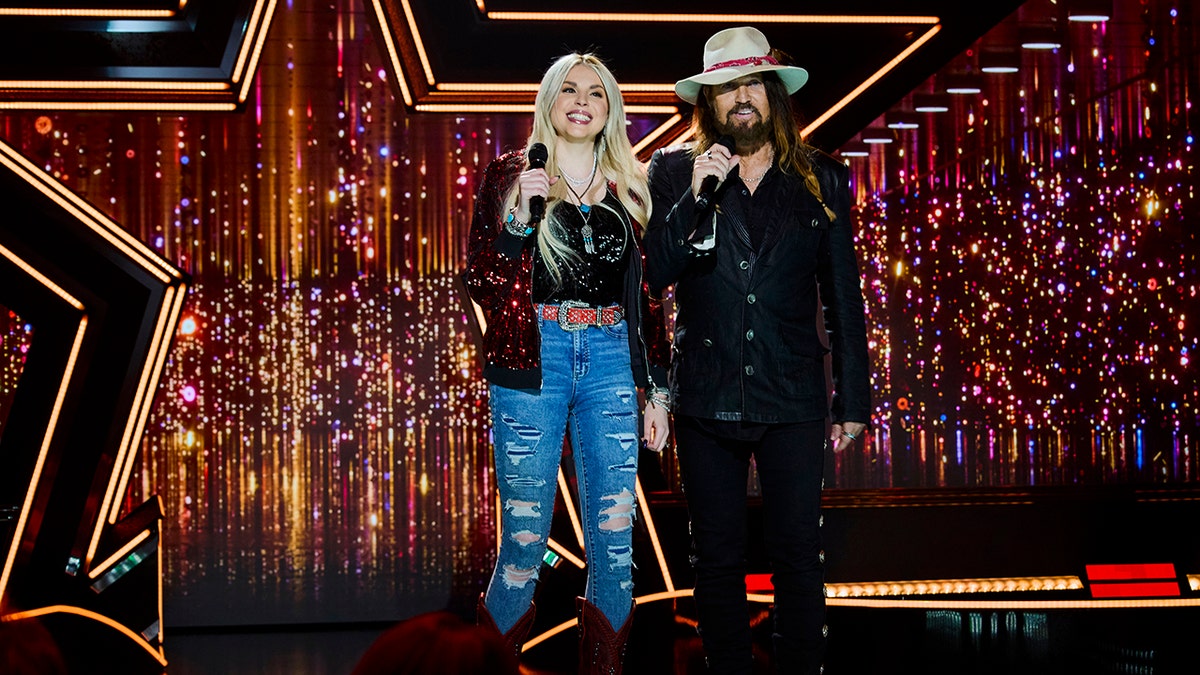 Firerose and Billy Ray Cyrus standing on stage