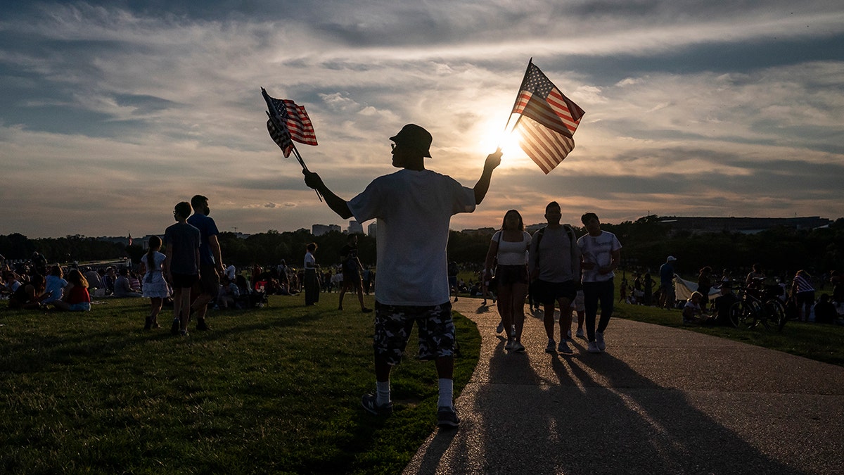 A vendor sells American flags at the Washington Monument on Independence Day