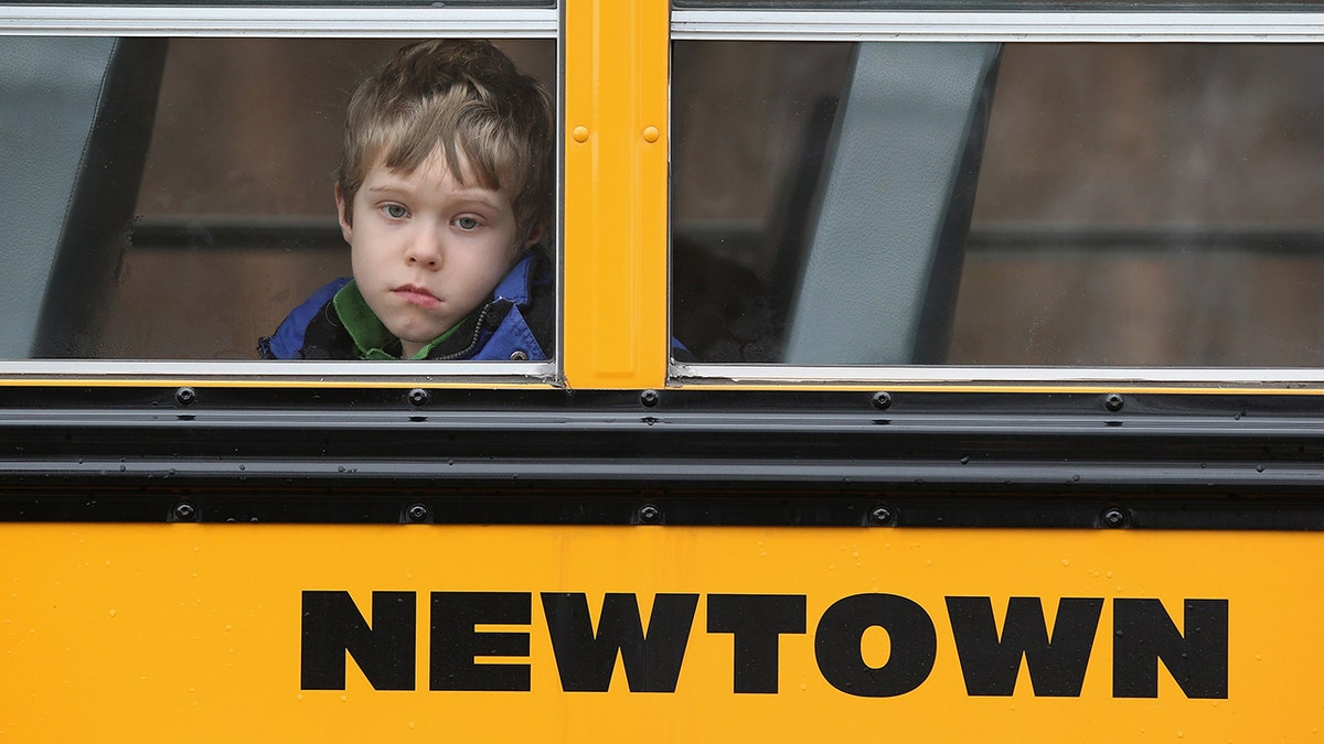 a child looks out the window of a bus in newtown ct