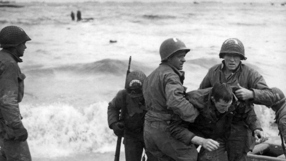 Unidentified survivors from a sunken LCVP (landing craft, vehicle, personnel, also known as a Higgins boat) are helped ashore at Omaha Beach during the invasion of Normandy, Normandy, France, June 6, 1944. (Photo by Underwood Archives/Getty Images)