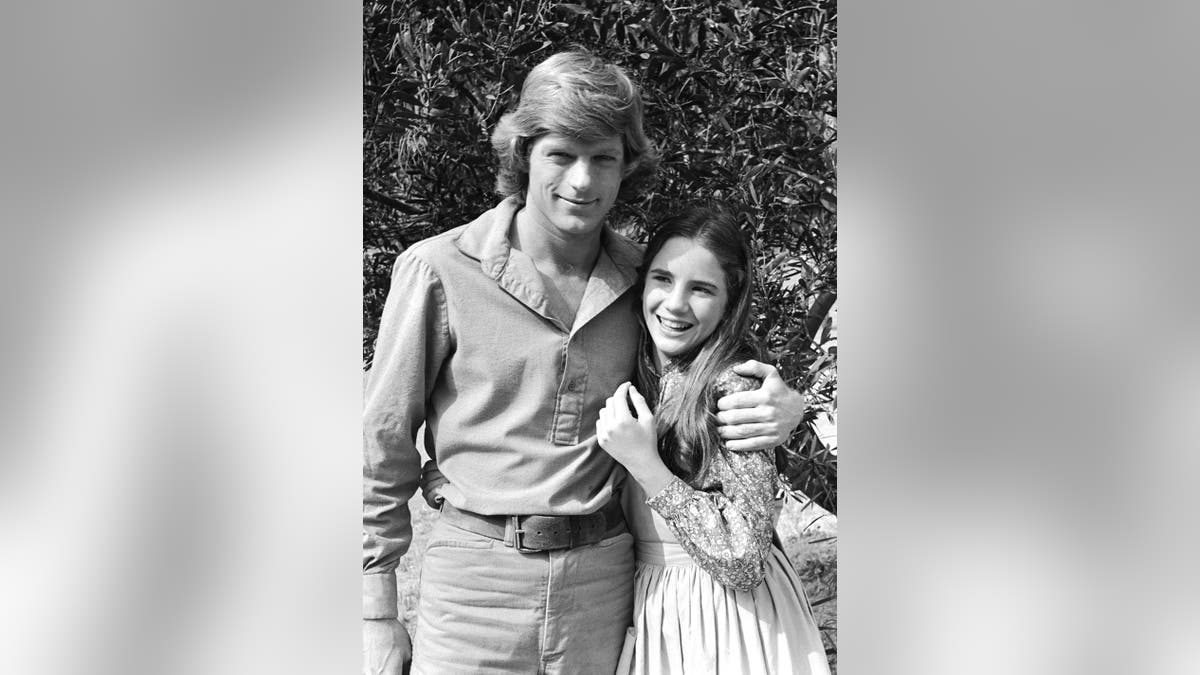 Melissa Gilbert smiling and being embraced by Dean Butler.