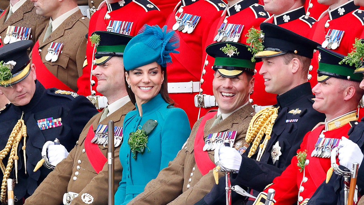 Kate Middleton smiling and surrounded by English guards.
