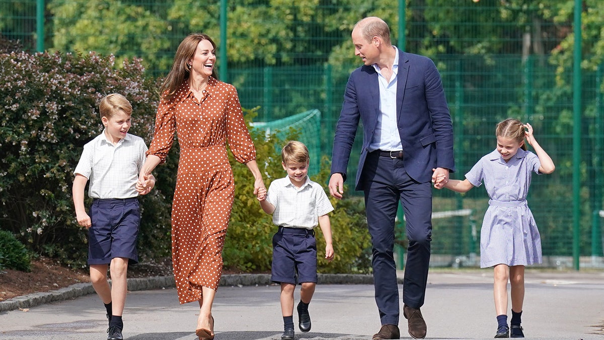 Kate Middleton and Prince William walking with their three children.